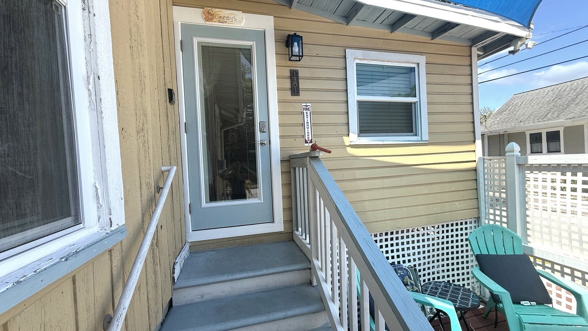 Une maison en bois avec une porte d’entrée, un petit porche et une fenêtre.
