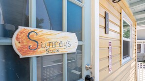 Une porte en bois sur laquelle est apposée une plaque indiquant : « Sunrays Suite ».