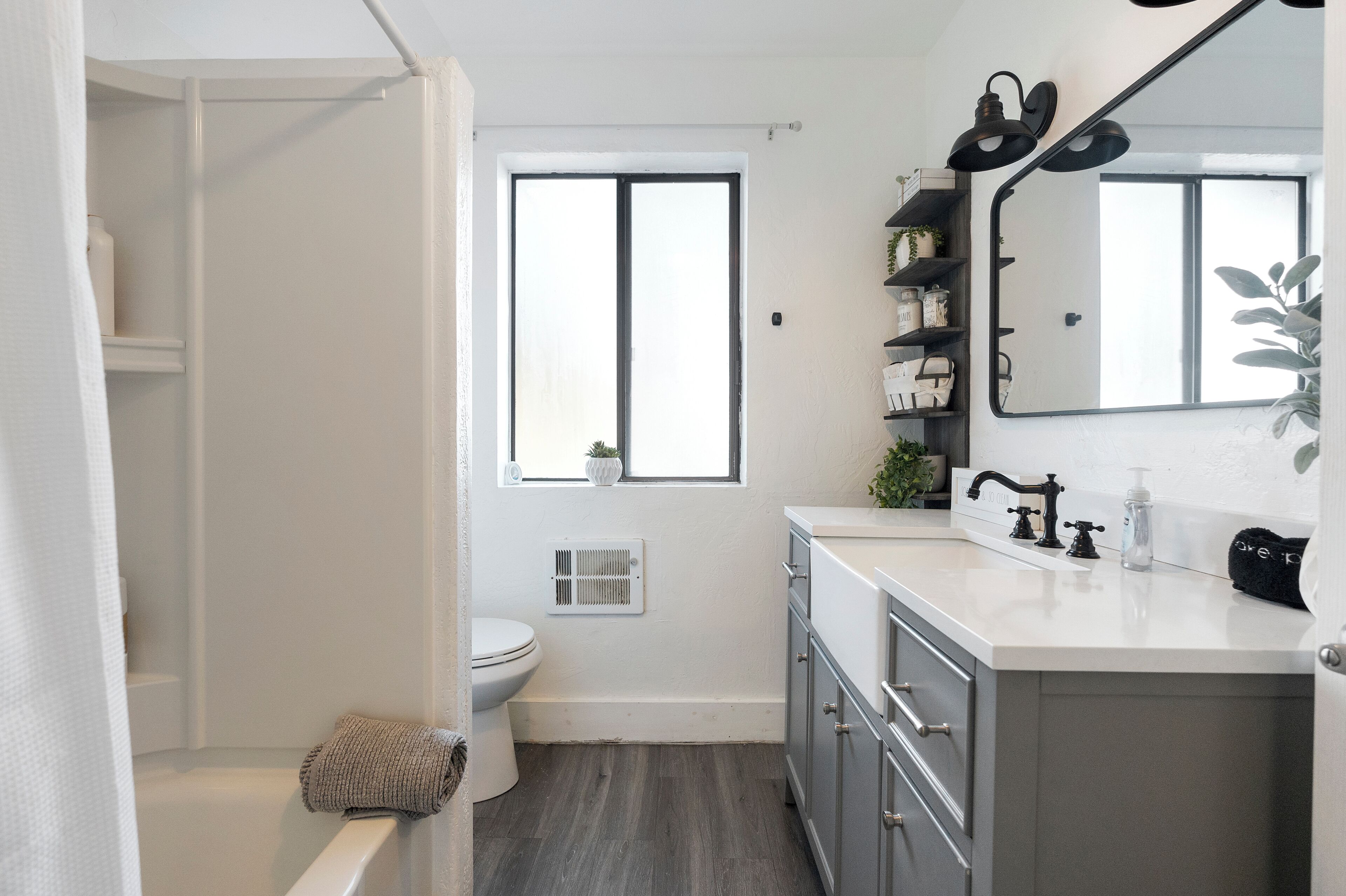 A modern bathroom with a toilet, sink, and mirror.