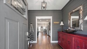 A hallway with a wooden floor, a red cabinet, and a chandelier. - Lovely Mountain Views Gatlinburg atop ChaletVillage HotTub GameRm Pets Sleeps10 (Gatlinburg)