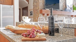 A kitchen counter with a bottle of wine, glasses, grapes, and bread. - 4BR ski-in/out Beaver Creek condo with mountain views (Avon)