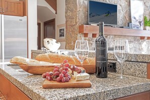 A kitchen counter with a bottle of wine, glasses, grapes, and bread. - 4BR ski-in/out Beaver Creek condo with mountain views (Avon)