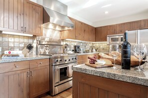 Una cocina moderna con armarios de madera, electrodomésticos de acero inoxidable y una encimera de granito.
