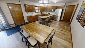 Une cuisine spacieuse, dotée de meubles en bois, d’un îlot central et d’appareils électroménagers modernes.