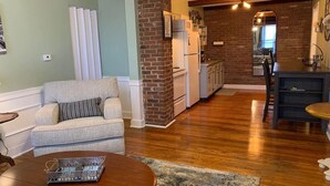 A living room with a sofa, a coffee table, and a kitchen in the background.