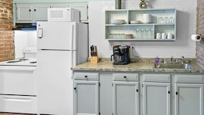 A kitchen with white appliances, a coffee maker, and a sink.