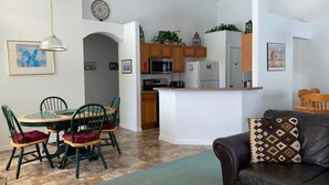 Una cucina moderna con mobili in legno, un'isola centrale e un'area pranzo con un tavolo rotondo e sedie.
