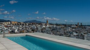 A swimming pool with a cityscape view, including a prominent tower and mountains in the background. - Estepona Roof Top View by Interhome (Estepona)