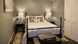 A neatly arranged bedroom with a bed, bedside tables, lamps, and a door. - Completely Remodeled-- 1/1 just 2 blocks from the base! (Angel Fire)