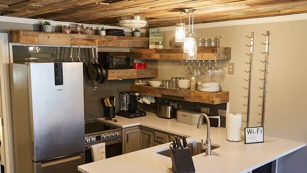 A modern kitchen with a central island, stainless steel appliances, and a rustic ceiling. - Completely Remodeled-- 1/1 just 2 blocks from the base! (Angel Fire)