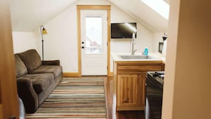 Un apartamento loft acogedor con kitchenette, sofá y televisor.