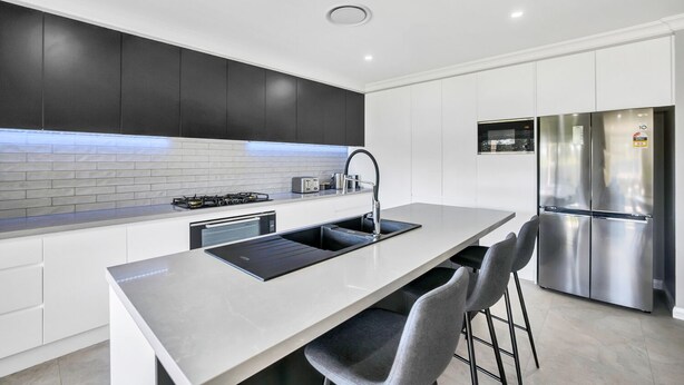 A modern kitchen with a central island, stainless steel appliances, and a sleek design.
