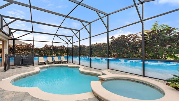 Una piscina interior con cerramiento de vidrio, dos jacuzzis y una zona de estar con sillones.