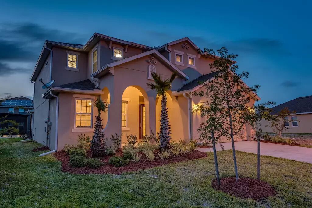 A two-story house with a covered front porch, a garage, and a well-maintained lawn.