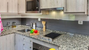 Una cocina con encimeras de granito, electrodomésticos de acero inoxidable y armarios de madera.
