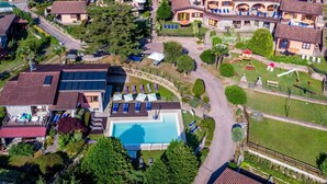 Una vista aerea di una zona residenziale con case, una piscina e un'area giochi.