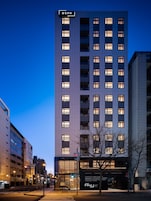A high-rise hotel with multiple floors, a prominent 'BSPK' sign at the top, and a modern glass entrance.