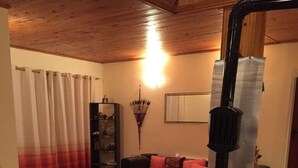 A cozy living room with a fireplace, a sofa, and a dining table. - Inviting 4-Bed Villa in Dolishte (Varna)