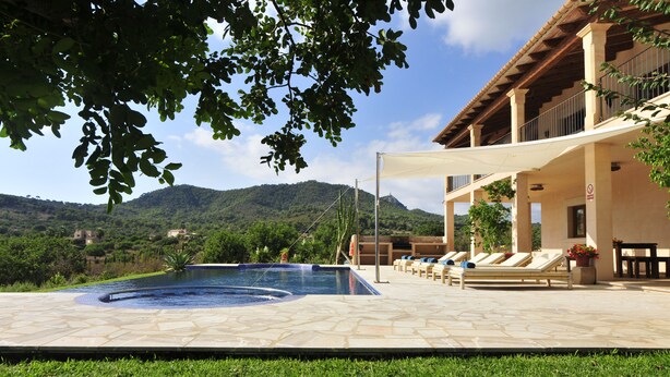 A pool area with lounge chairs and a view of mountains. - Finca Mimosa - haven of peace with amazing views (Cala D'or)