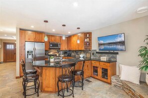 Enjoy cooking in this well-equipped kitchen with a central island, sink, and refrigerator.