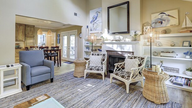 A spacious living room with a fireplace, comfortable seating, and a view of the kitchen. - Sunset Rentals | Lawton 45 | Dog Friendly | (Hilton Head Island)