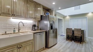 A modern kitchen with a built-in dishwasher, stainless steel refrigerator, and a coffee maker on the countertop. - Sunset Rentals | Lawton 45 | Dog Friendly | (Hilton Head Island)