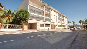 Um hotel com vários andares, fachada plana, varandas e garagem.