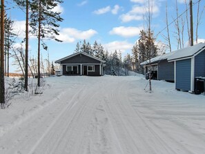 Una strada di accesso ricoperta di neve che porta a una casa con un garage.