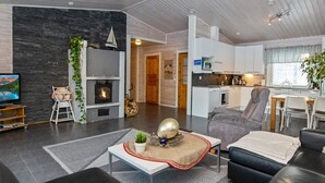 En moderne stue med pejs, fjernsyn og spiseplads.