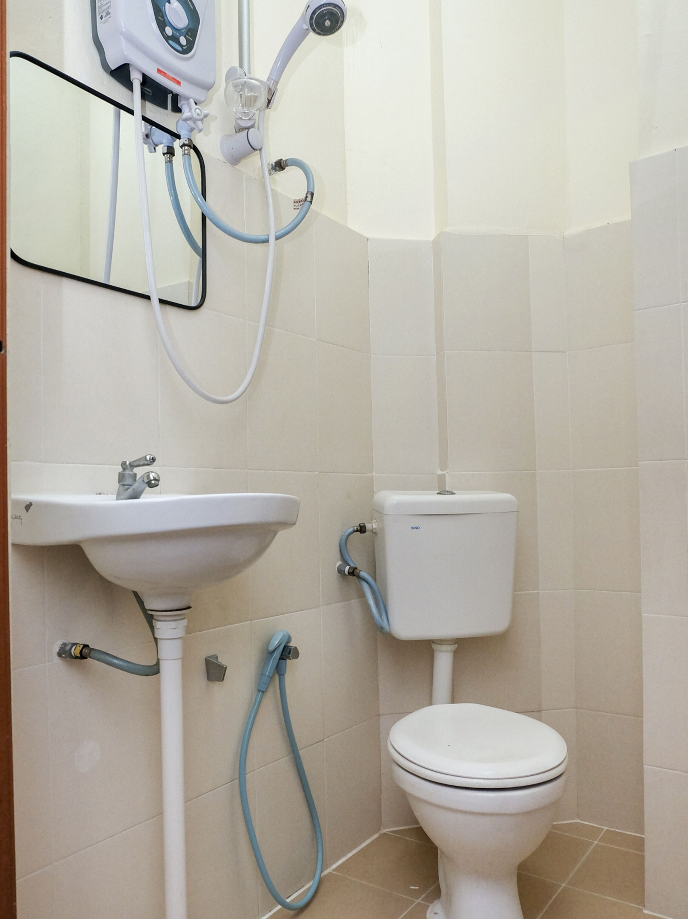 A bathroom with a white sink, toilet, and shower unit.