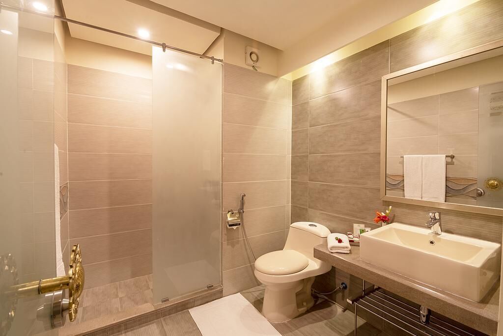 Ein modernes Badezimmer mit Duschkabine, Toilette und Waschbecken mit Spiegel.