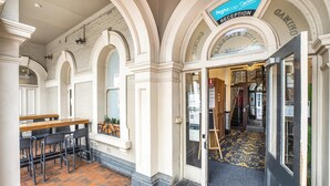 A reception area with a sign for 'Nighthop Special Reception' and 'Ramsgate Hotel'. There is a wooden table with chairs and a patterned carpet leading to the entrance. - Ramsgate Hotel by Nightcap Social (Henley Beach)