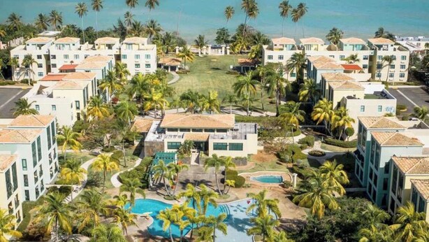 A resort with multiple buildings, a central pool area, and a view of the ocean. - Aquatika “A Cozy Paradise” (LOIZA)