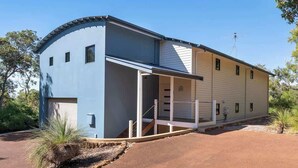 A two-story building with a curved facade, a covered porch, and a garage. - Eagle Vista—Beachside Bliss with Bushland Serenity (Eagle Bay)