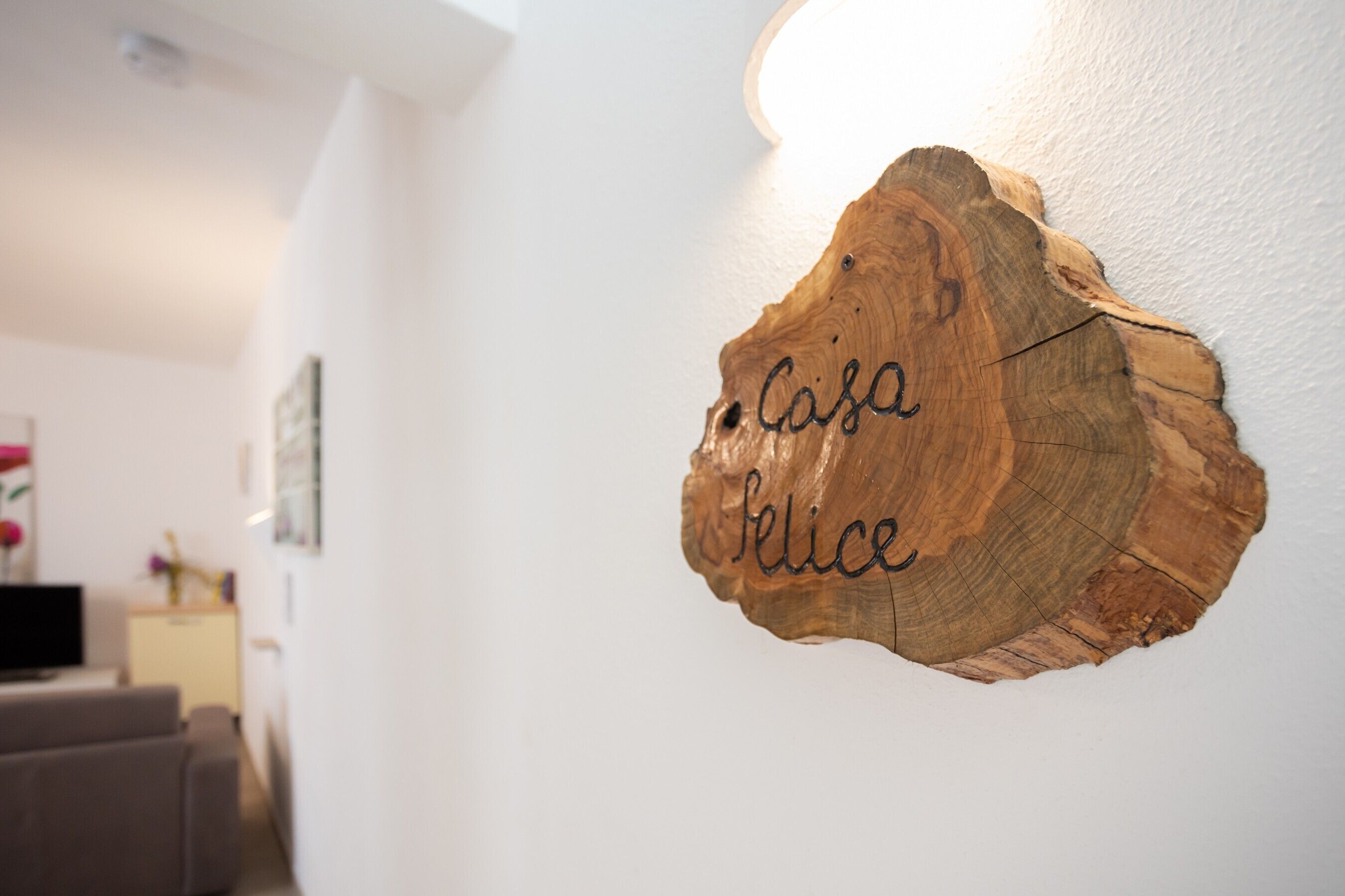 Decoración de pared de madera con el nombre 'Casa Felice' grabado.