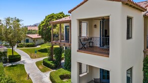 Um edifício residencial com varanda, um caminho e vista para uma montanha.