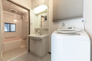 A bathroom with a shower, a sink, and a mirror. - Urban Stay Shinagawa (Tokyo)