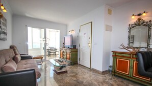 A living room with a sofa, a glass coffee table, a television, and a cabinet with a mirror. - Angel - sea view apartment in Calpe (Calpe)