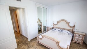 A bedroom with a bed, a nightstand, a mirror, and a wardrobe. - Angel - sea view apartment in Calpe (Calpe)