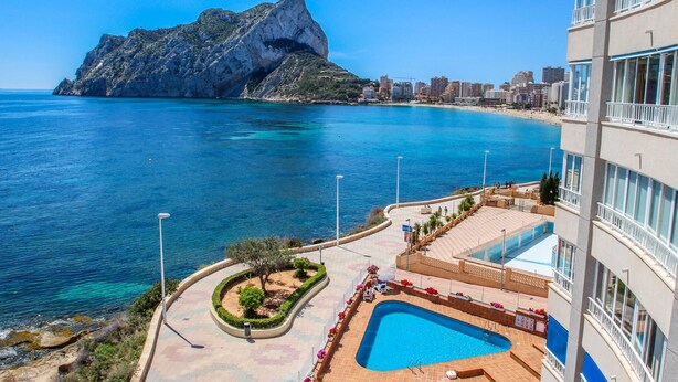 A hotel with a pool, a view of the sea, and a mountain in the background. - Angel - sea view apartment in Calpe (Calpe)