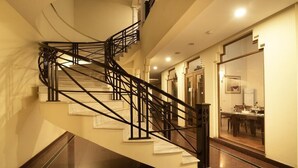 A spiral staircase with black railings in a well-lit hallway. - Hotel One Tariq Road Multan (Multan)