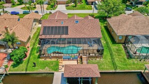 A residential property with a swimming pool, a dock, and a covered patio area.