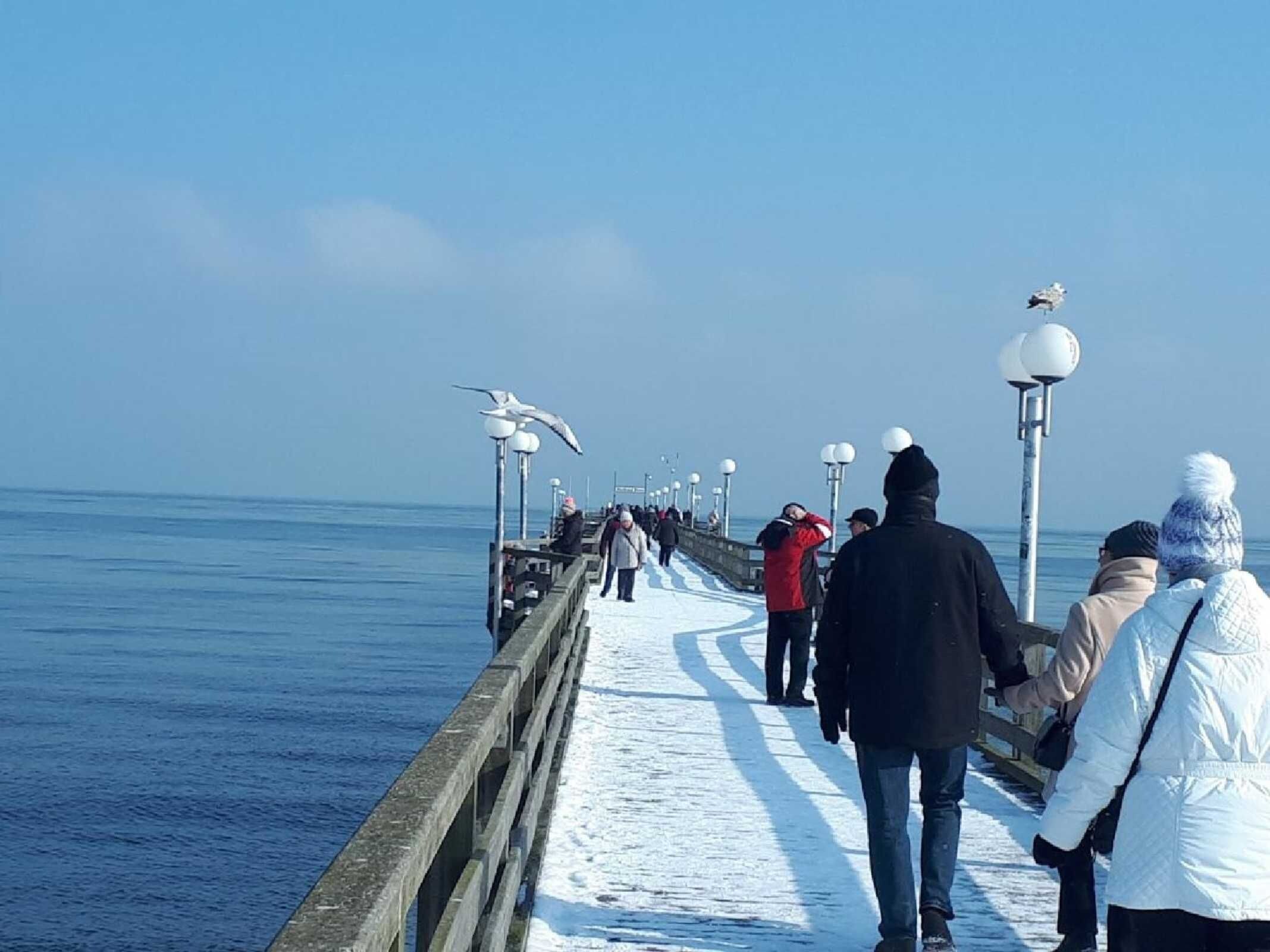 Een steiger die zich uitstrekt over het water, met mensen die erover lopen.