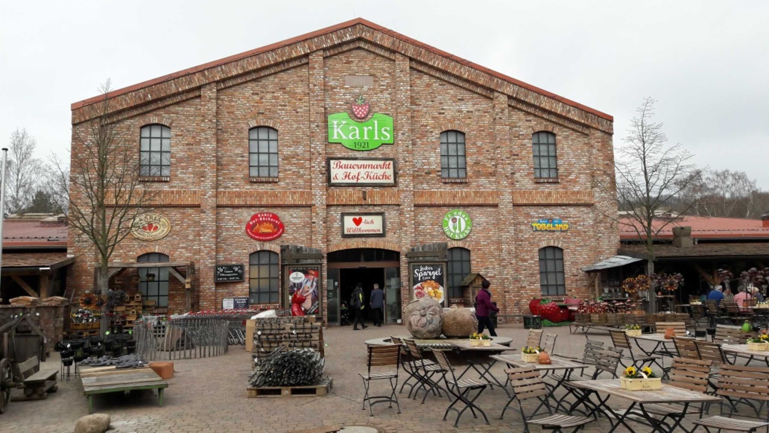 A brick building with signs for 'Karls 1921' and 'Bauernmarkt & Hof-Küche'.