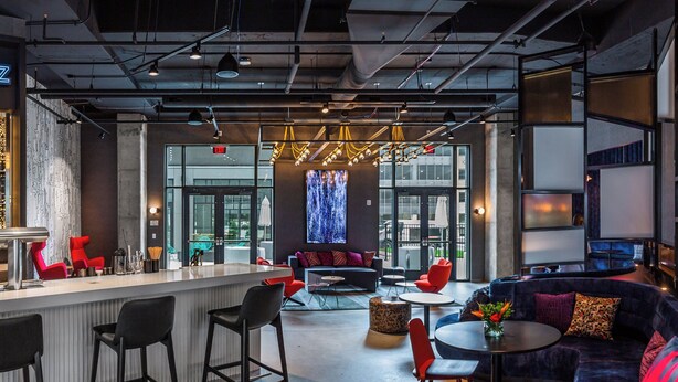 Ein stilvoller Lounge-Bereich mit Bar, Sitzgelegenheiten und einem großen Bildschirm.