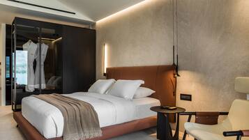 A modern bedroom with a large bed, bedside table, and a chair.