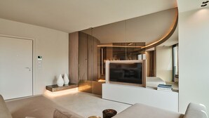 A modern living room with a large flat-screen TV, a sofa, and a coffee table. - RESIDENZA II LUXURY APARTMENT (Cattolica)
