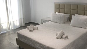 Une chambre d’hôtel moderne avec un grand lit, une table de chevet et une petite table d’appoint.