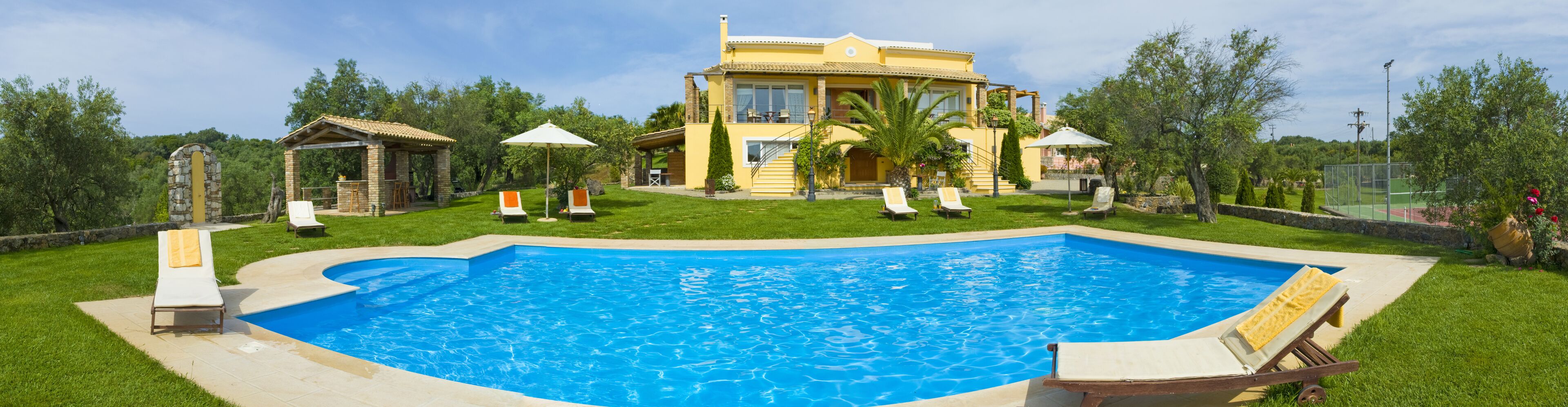 A large swimming pool with a house in the background.