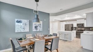 A modern kitchen with white cabinets, stainless steel appliances, and a central island. - 3bd/2ba condo close to Disney, Storey Lake (Kissimmee)